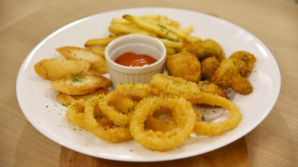 Onion ring mix with french fries, mushroom served on large plate