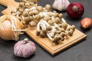 Broun Shimeji mushrooms on cutting board.