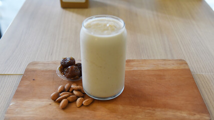 Milkshake with dates and almond nut served on the table