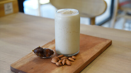 Milkshake with dates and almond nut served on the table