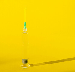 One medical syringe on yellow