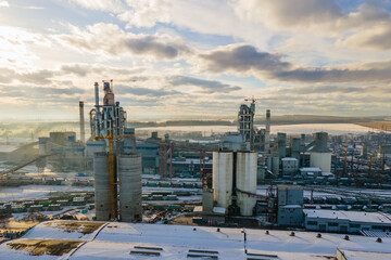 Obraz premium Aerial view of cement plant with high factory structure and tower crane at industrial production area.