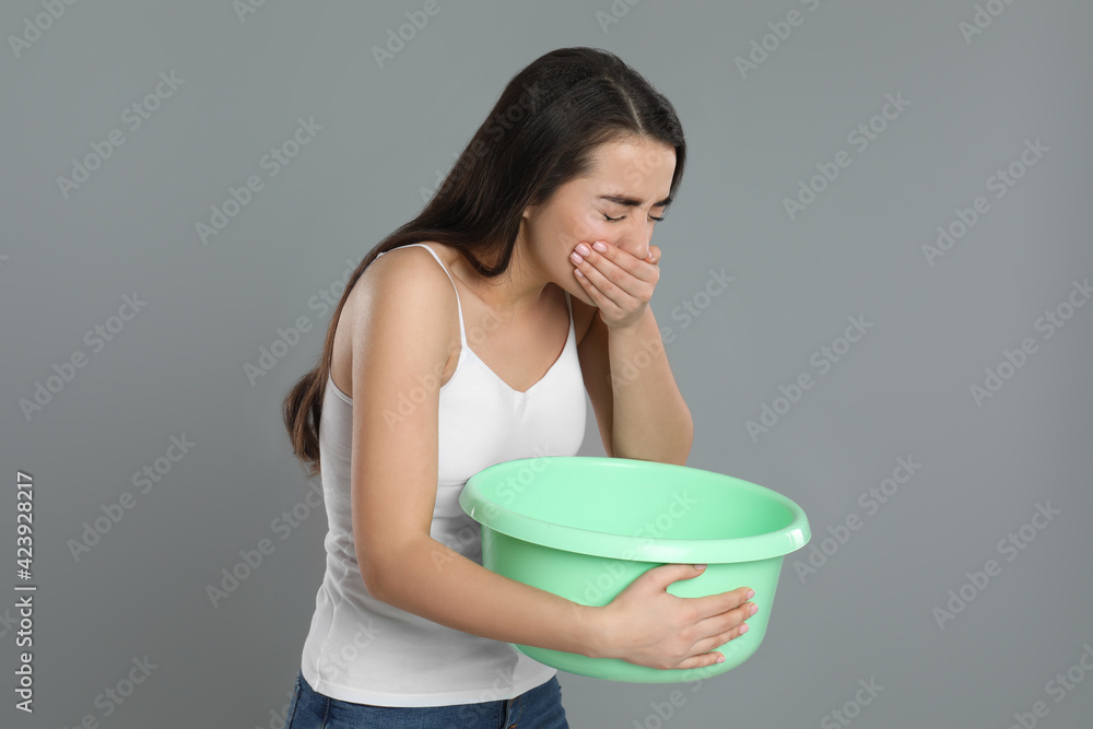 Canvas Prints Young woman with basin suffering from nausea on grey background. Food poisoning