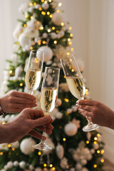 People clinking glasses with champagne at home, closeup