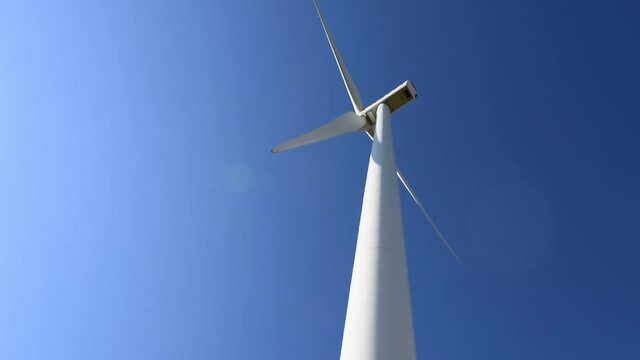 Vista inferior de un molino e&oacute;lico aprovechando el viento para generar electricidad sostenible