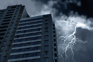 Dark cloudy sky with lightning over building. Stormy weather