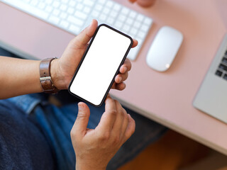 Businesswoman using smartphone include clipping path above computer desk