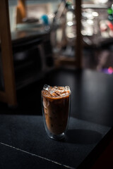 Close-up glass of iced coffee with milk on the table