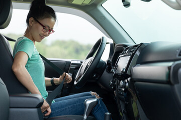 Fototapeta na wymiar Woman driver buckle up the seat belt before driving car