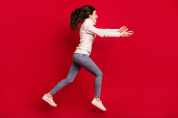 Full length photo of friendly kind young lady wear collar pullover jumping high running open arms isolated red color background
