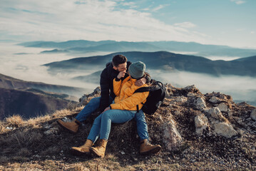 Fototapeta premium happy couple man and woman tourist at top of mountain during a hike in summer
