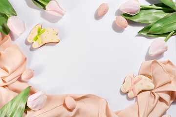 Gingerbread easter cookies with pink eggs on pastel cloth and light background