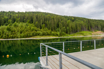 Front view of beautiful large lake and incredible green trees in forest. Concept of beautiful landscape nature.
