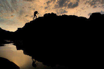 Young male tourists climbing mountains Ideas for personal development and goals in the life of a climber with a backpack.