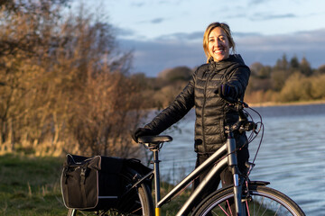 Fototapeta na wymiar young woman smiling with her touring bike at Blessington lakes Wicklow Ireland