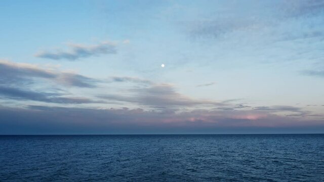 Mare calmo al tramonto con luna