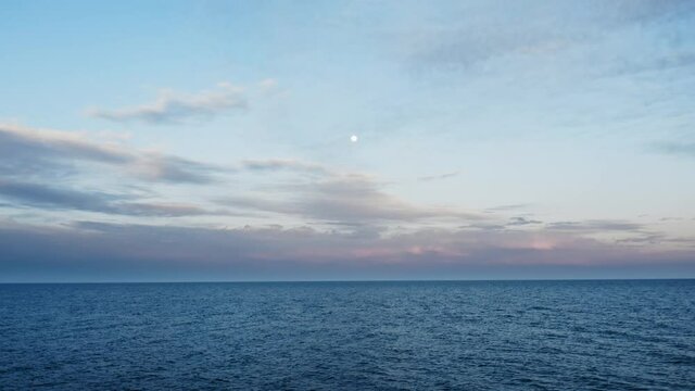 Mare calmo al tramonto con luna