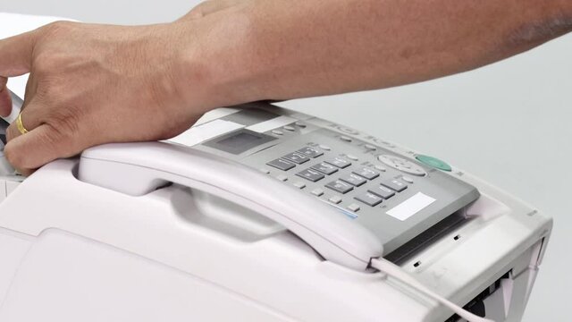 hand man are using a fax machine in the office, equipment for data transmission