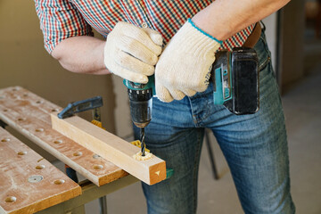 Worker drills timber with cordless drill