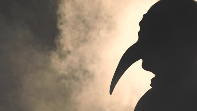 Silhouette of a masked man in the smoke