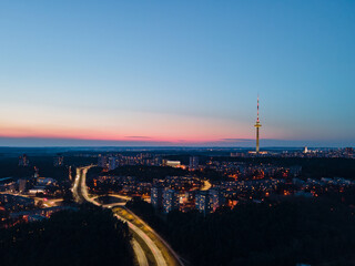 TV tower and residential area - evening in Vilnius - aerial shot almost at night. 