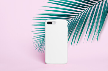 White phone case mockup isolated on pink background with palm leaves, smartphone iPhone back view