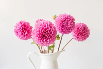 Deurstickers Closeup of bright pink dahlia blossom amongst bunch in white jug (selective focus) © Natalie Board