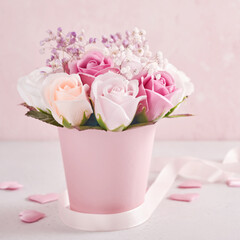 Festive composition with beautiful delicate roses flowers in pink round box on light pink background. Happy Mothers Day Greeting card. Square image.