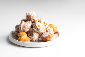  Small  deep fried doughs on trhe plate with sugar. Spanish Bonuelos de viento  background.
