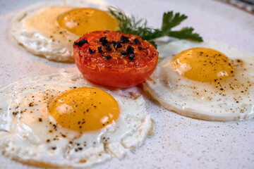 Fried eggs with tomato and herbs