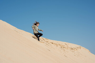 cute little girl playing in the sand dunes
