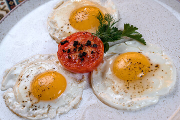 Fried eggs with tomato and herbs