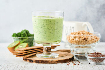 Detox green smoothie with kale, spinach and kiwi on a light gray slate, stone or concrete background. Top view with copy space.