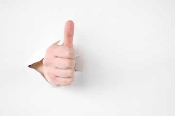 Female hand makes thumbs up gesture closeup