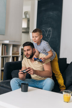 Father And Son Playing Video Games At Home