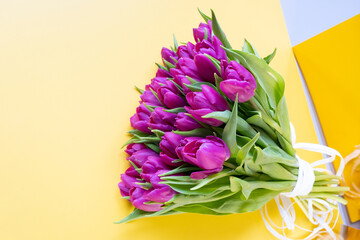 Beautiful tulips on the yellow background. Spring flowers bouquet. Easter and spring greeting card. Woman day concept. Spring banner. Copy space for text