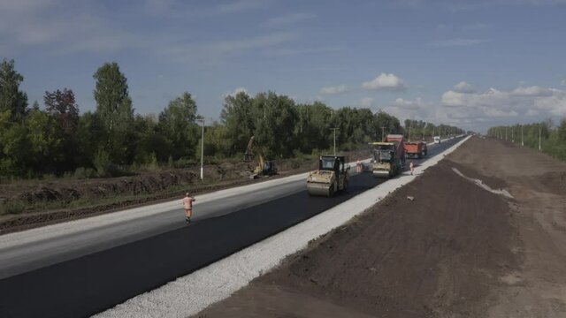 The copter takes off over the road on which the asphalt is laid