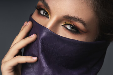 Portrait of stylish woman wearing leather neck gaiter instead of prevention mask.