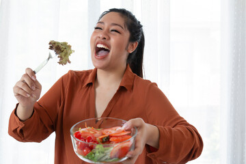 Happy overweight woman eating salad. Overweight Woman Eating Bowl Of Fresh Vegetables. Obesity young women eat green organic vegetables. obesity plus size women eat green organic vegetables
