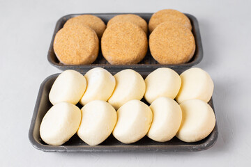 Semi-finished frozen fish cutlets, cottage cheese syrniki. Raw meals, blanks from shop, white background. Fast cheap food, saves time in the kitchen. Hand made, lean recipe idea