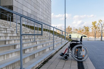 Wheelchair empty in front of concrete stairs.