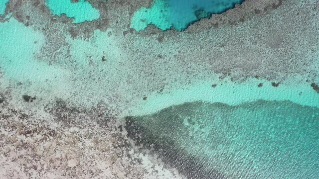 Aerial drone shot of crystal clear water and sand on Island in the sea