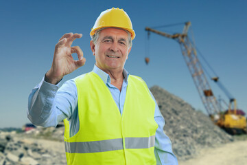 Builder on construction site background making okay gesture