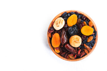 Healthy food snack: dried fruits, natural. sun dried organic mix of dried apricots, figs, raisins, dates, cranberries, cherries, goji berries, prunes in bowls on white background, top view