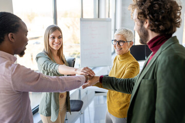 Obraz premium Group of business people with hands together in office. Teamwork success concept