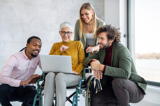 Senior businesswoman with disability in wheelchair working with successful business team