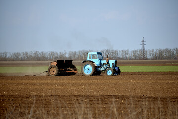 Obraz premium Rural business,tractor in field cultivates soil. Farming in spring