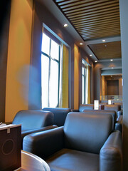View into cozy living room bar lounge with big leather armchairs in front of panoramic oceanview...