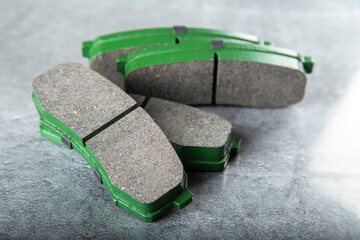 a set of new green brake pads on a gray table