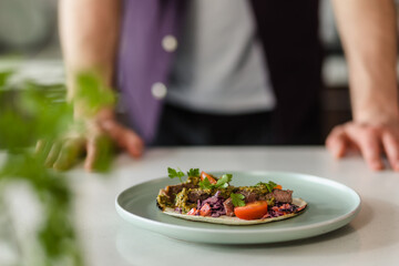 Close Up Mexican food tacos presentation on white table at home in modern kitchen with chef in Background, Fresh Food Homemade Styling Presentation, Copy Space